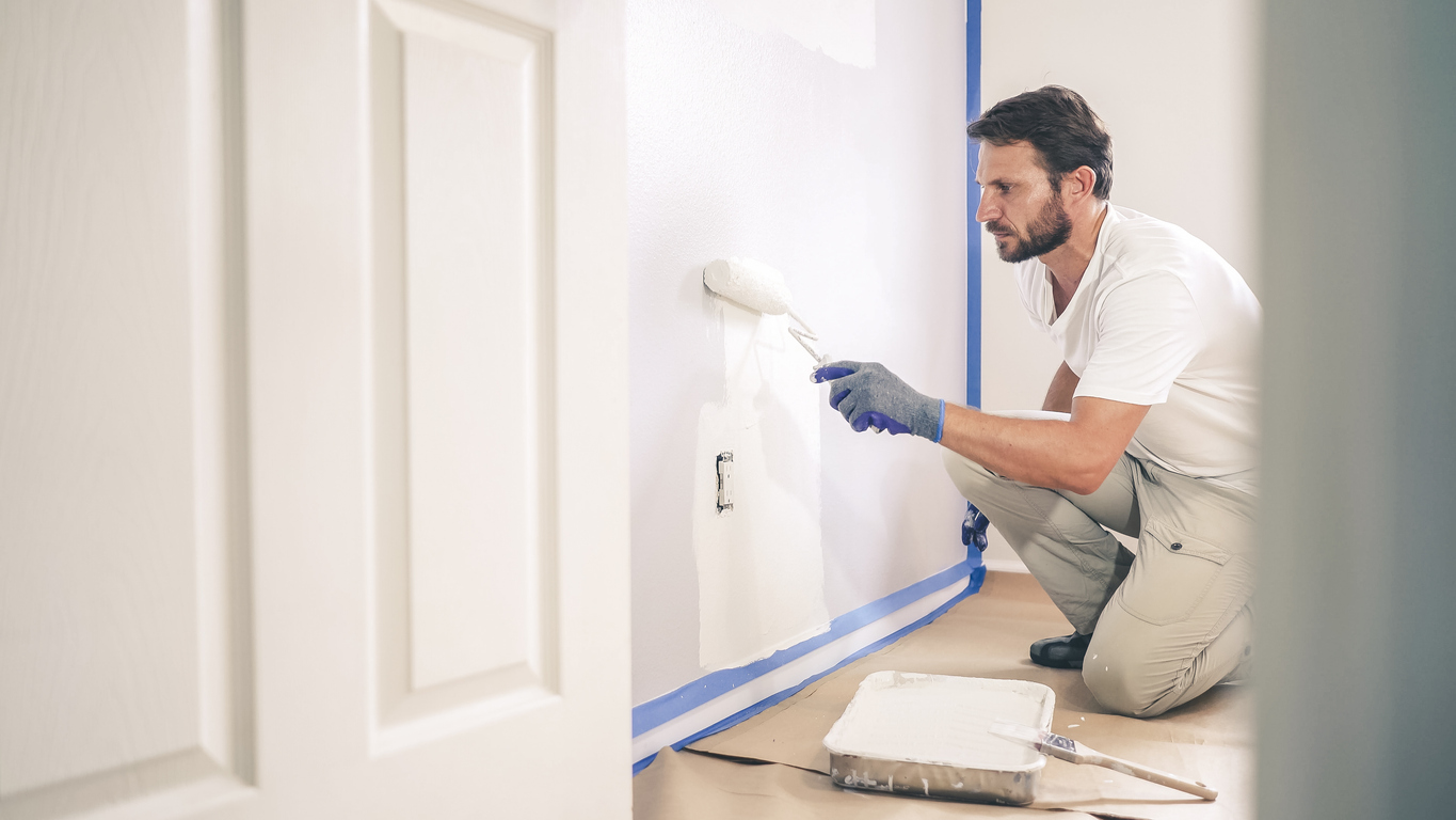 Painter man painting the wall in home